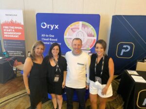 Oryx Dental Professionals in front of trade show sign