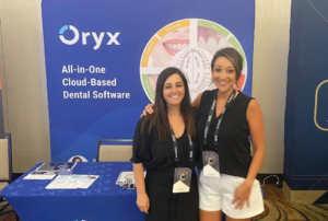 Dental professionals at event in front of sign